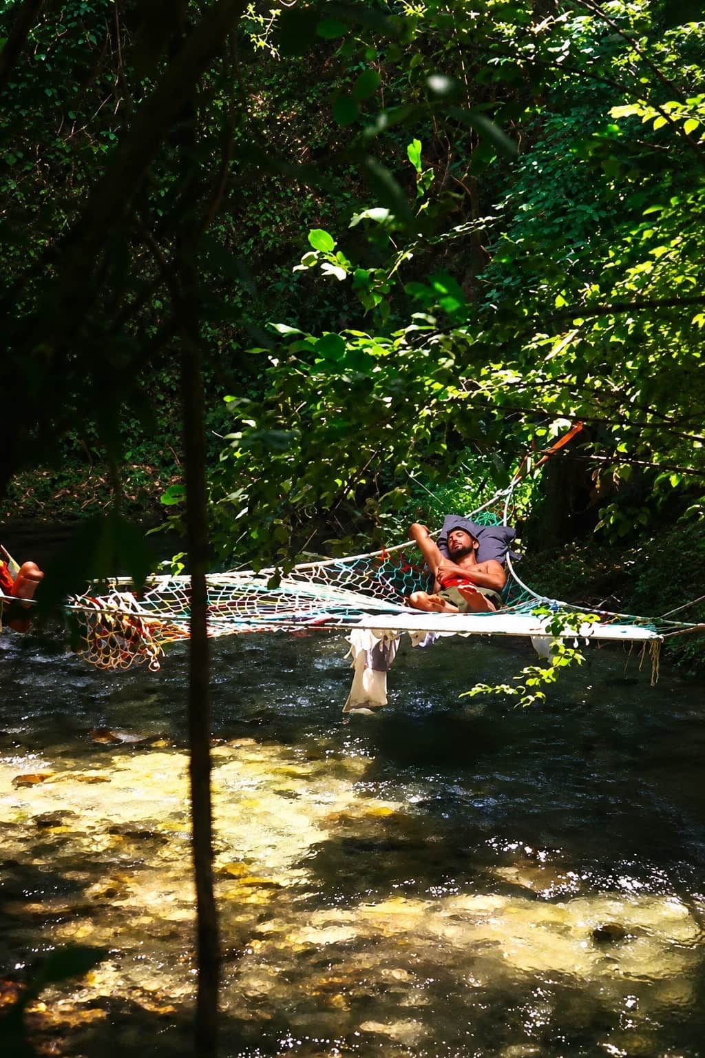 Ospite disteso sulle amache sospese sopra il fiume Lao, nell'angolo di paradiso del River Camp